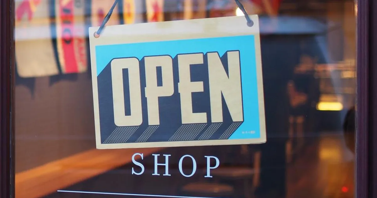 Open sign hanging on the glass door of a small business storefront