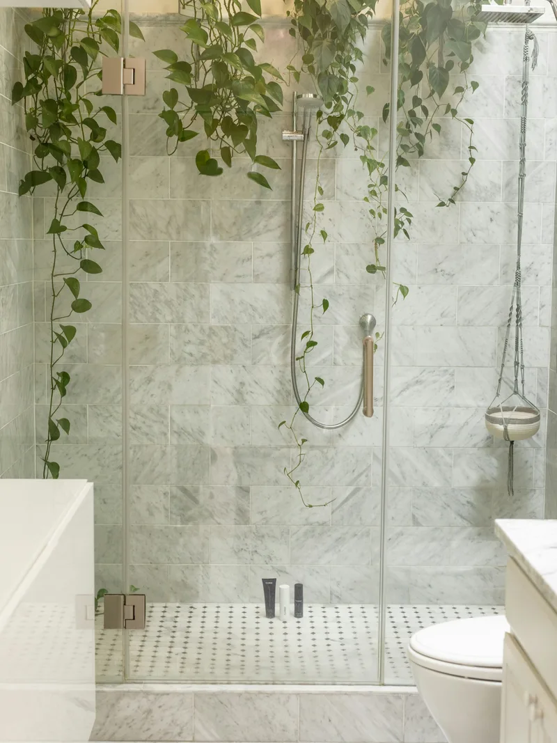 Frameless glass shower door with marble tile walls, a shower door service we offer in Port Perry
