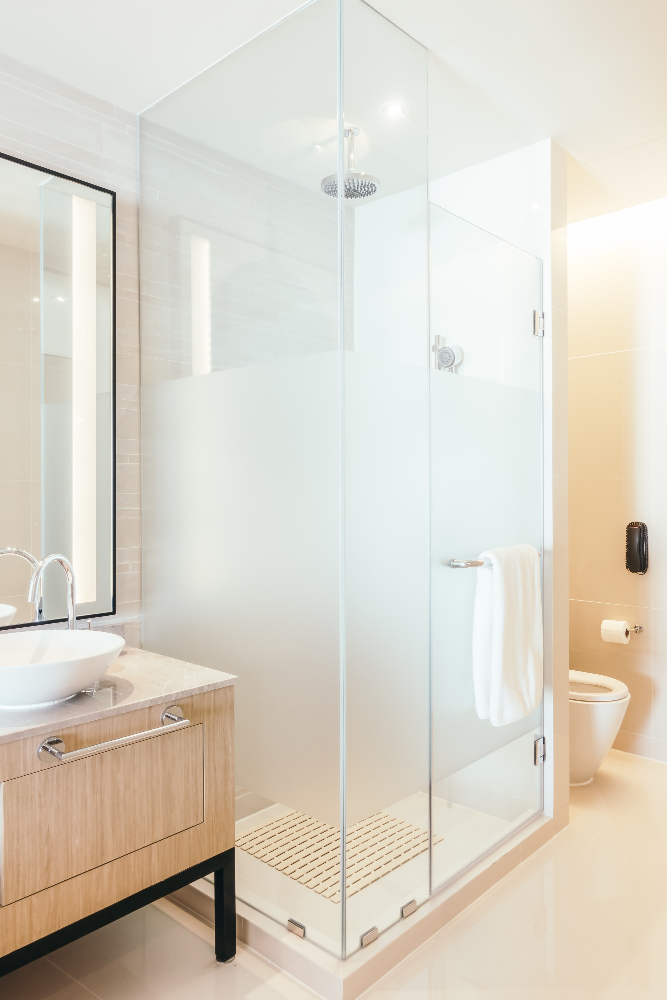 Modern bathroom with frosted glass shower and wooden vanity